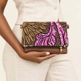 Viola Bronze clutch held with a neutral linen outfit in a studio